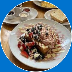 “French toast topped with fresh berries and cream.”