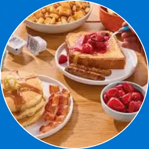 “Breakfast platters featuring a hearty combination of eggs, pancakes, bacon, sausage, and toast for a complete morning meal.”