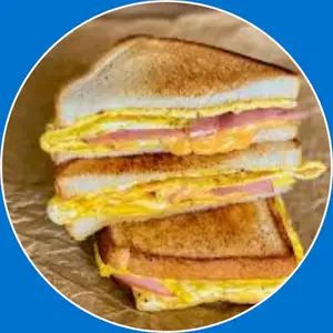 “Grilled sandwich with ham, eggs, and melted cheese.”