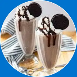 “Oreo cookies milkshake served in a tall glass with whipped cream and crushed Oreos.”