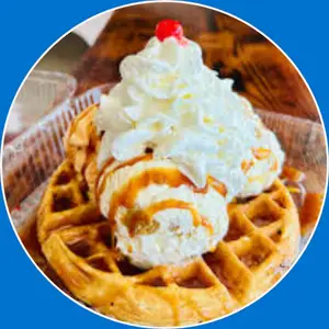 “Belgian waffle sundae with a warm, crispy waffle topped with ice cream, syrup, and whipped cream.”