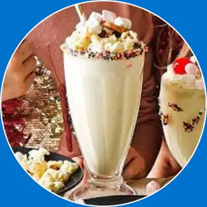 “A tall glass of creamy vanilla milkshake topped with whipped cream.”