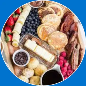 “Pancake platter featuring a stack of fluffy pancakes served with butter, syrup, and breakfast sides.”